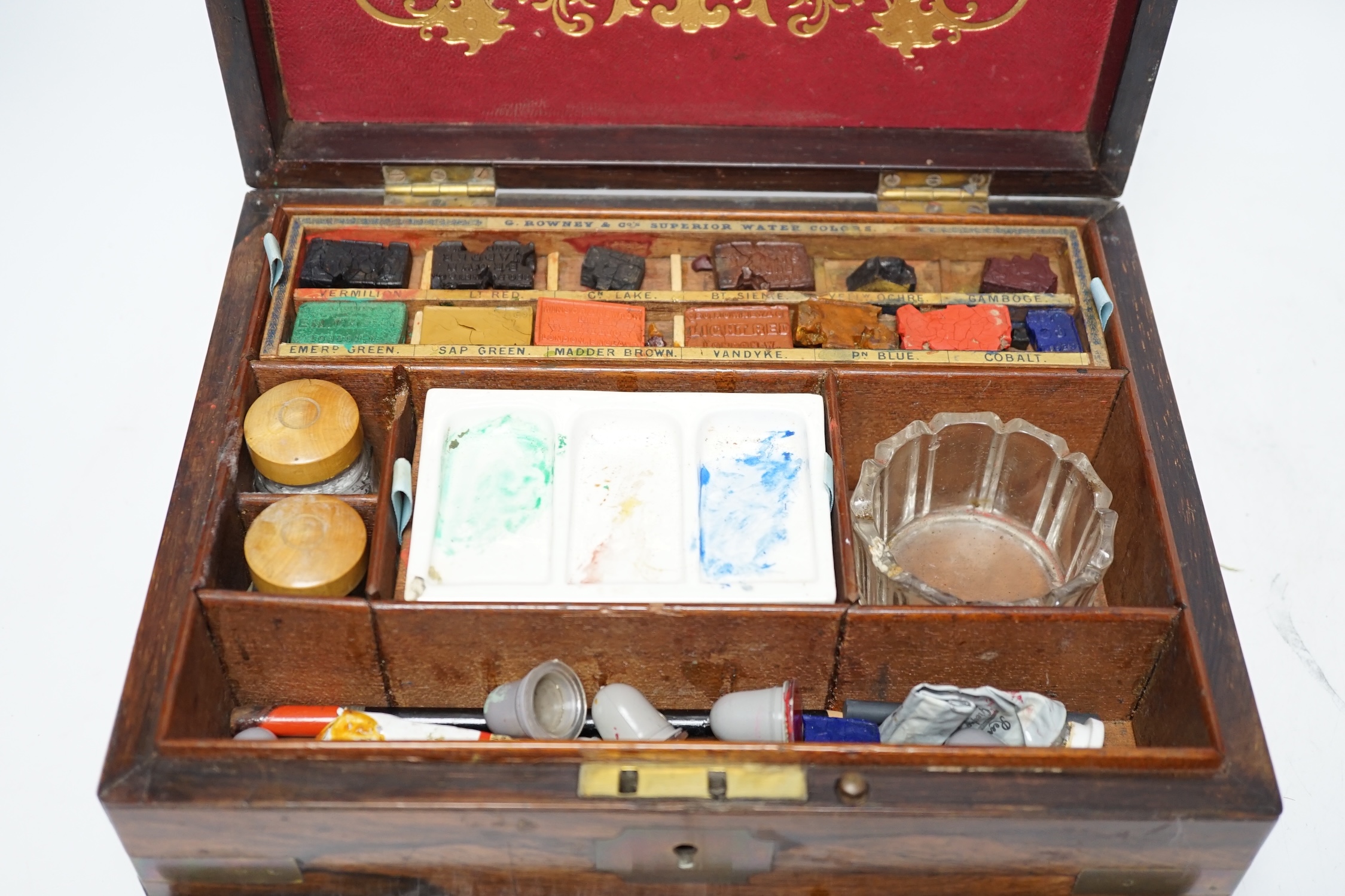 An Edwardian G Rowney & Co brass mounted artist’s paint box with watercolour blocks, tubes and charcoal sticks